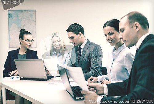 Image of business team with laptop having discussion