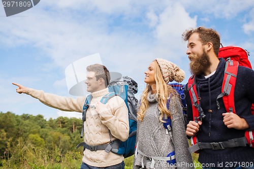 Image of group of smiling friends with backpacks hiking