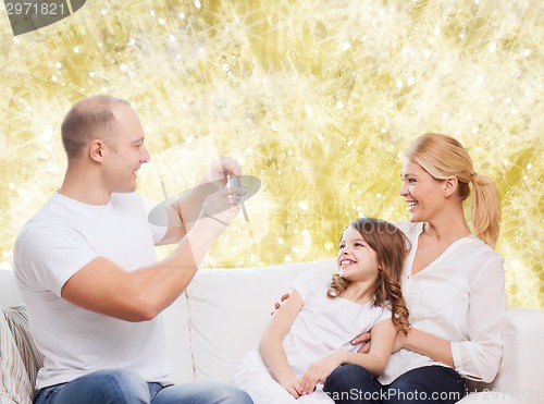 Image of happy family with camera at home