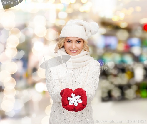 Image of smiling woman in winter clothes with snowflake