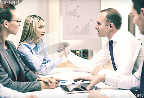 Image of businesswoman and businessman arm wrestling