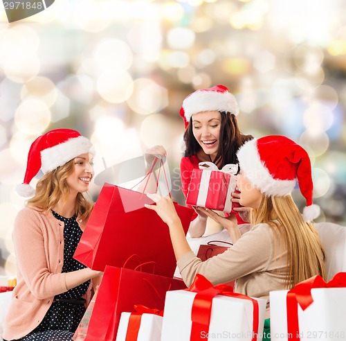 Image of smiling young women in santa hats with gifts