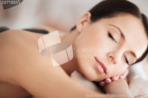 Image of beautiful woman in spa salon with hot stones