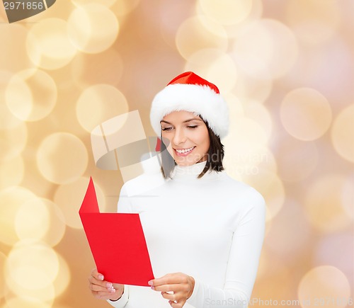 Image of smiling woman in santa hat with greeting card