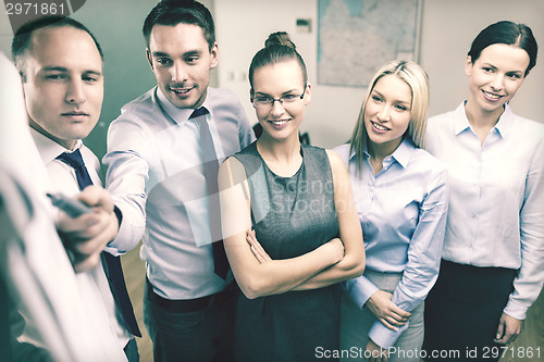 Image of business team with flip board having discussion