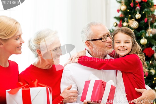 Image of smiling family with gifts at home