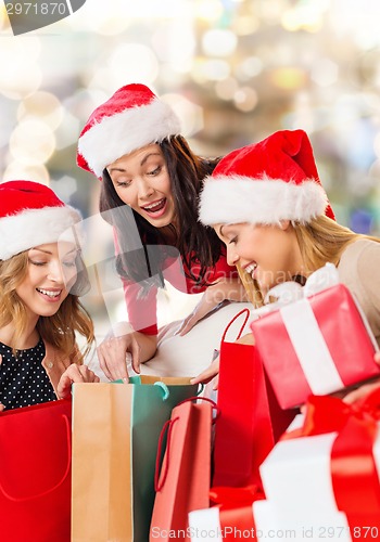 Image of smiling young women in santa hats with gifts