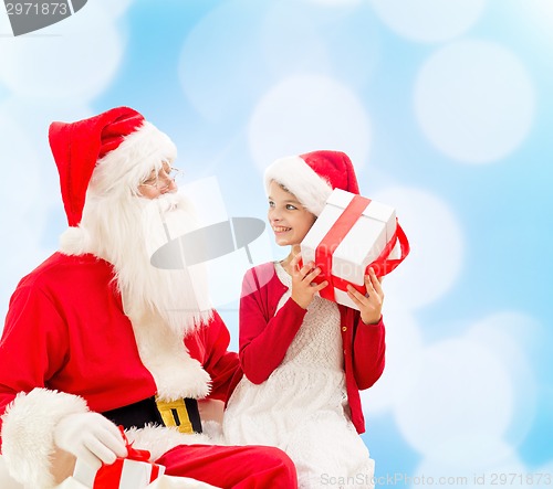 Image of smiling little girl with santa claus and gifts