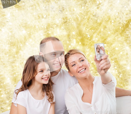 Image of happy family with camera at home