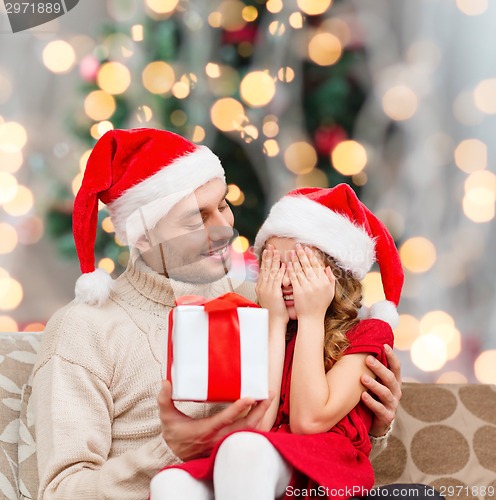 Image of smiling daughter waiting for present from father