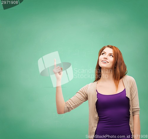 Image of smiling teenage girl pointing finger up