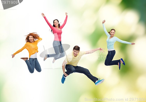 Image of group of smiling teenagers jumping in air