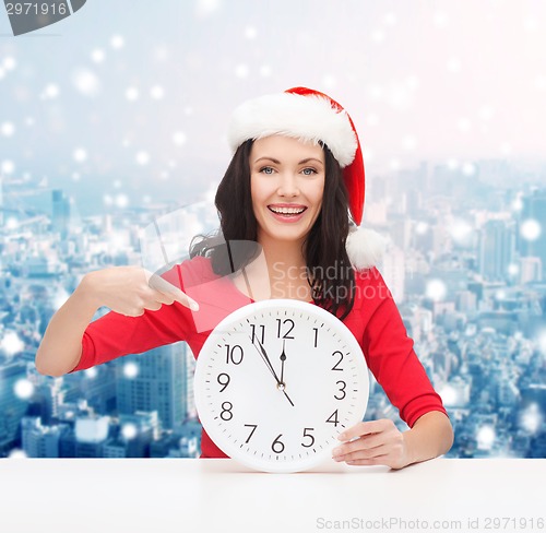 Image of smiling woman in santa helper hat with clock