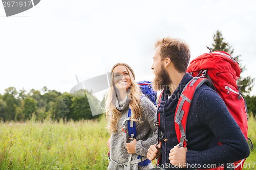 Image of smiling couple with backpacks hiking