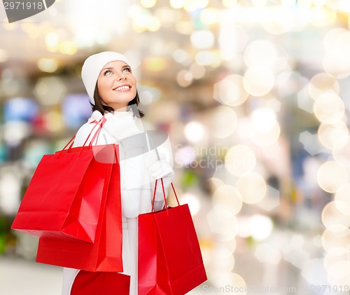 Image of smiling young woman with red shopping bags