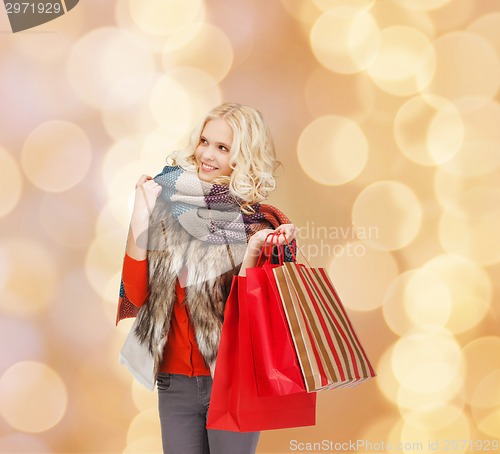 Image of smiling young woman with red shopping bags