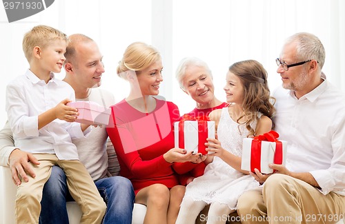 Image of smiling family with gifts at home