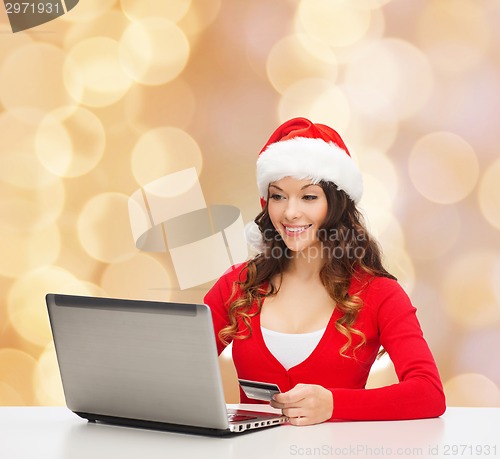 Image of smiling woman with credit card and laptop