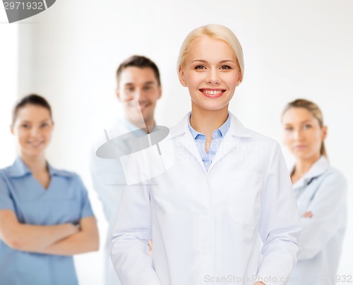 Image of smiling female doctor with group of medics