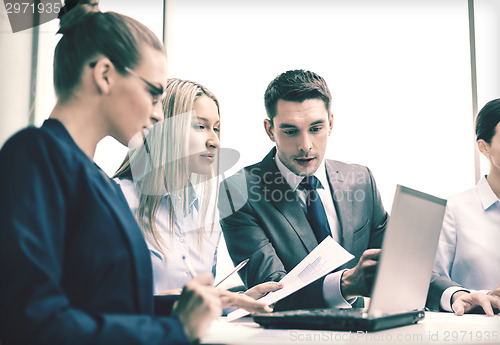Image of business team with laptop having discussion