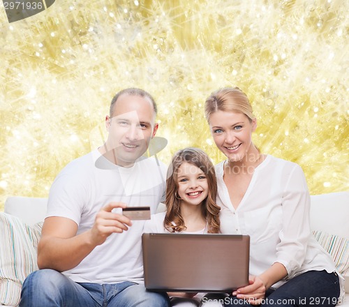 Image of happy family with laptop computer and credit card