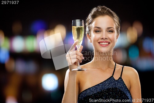 Image of smiling woman holding glass of sparkling wine