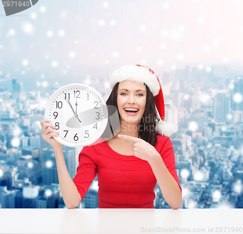 Image of smiling woman in santa helper hat with clock