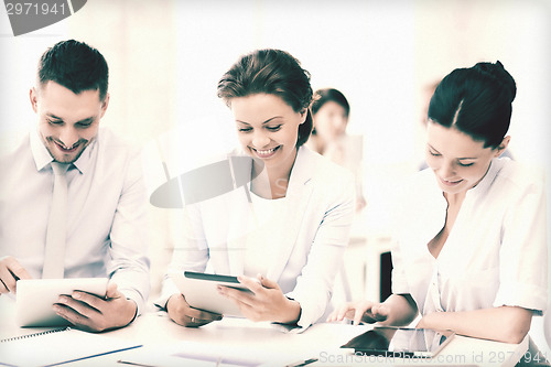 Image of business team working with tablet pcs in office