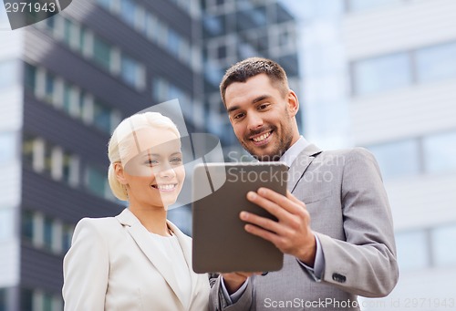 Image of smiling businessmen with tablet pc outdoors