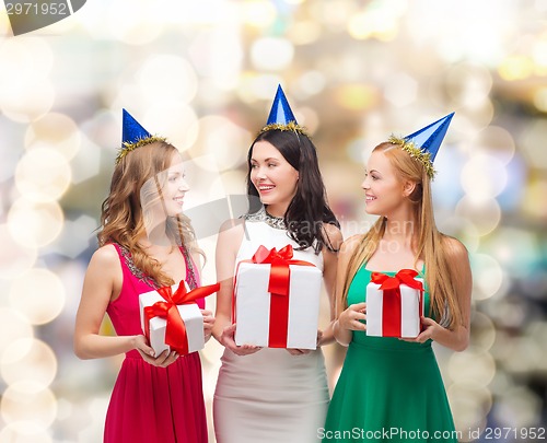 Image of smiling women in party caps with gift boxes