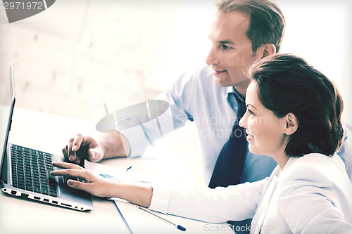 Image of man and woman working with laptop in office