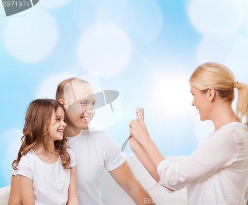 Image of happy family with camera at home