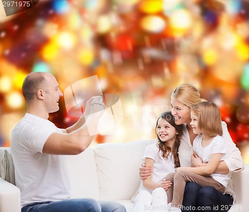 Image of happy family with camera at home