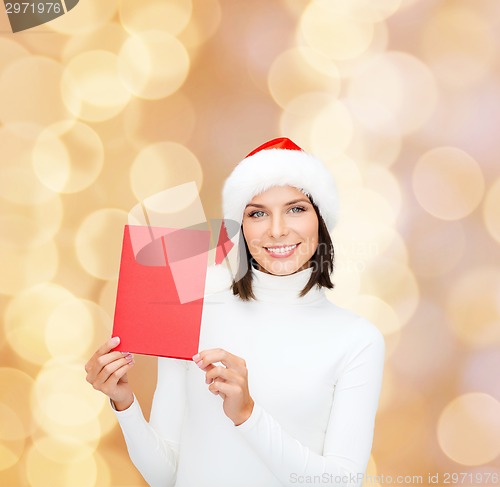 Image of smiling woman in santa hat with greeting card