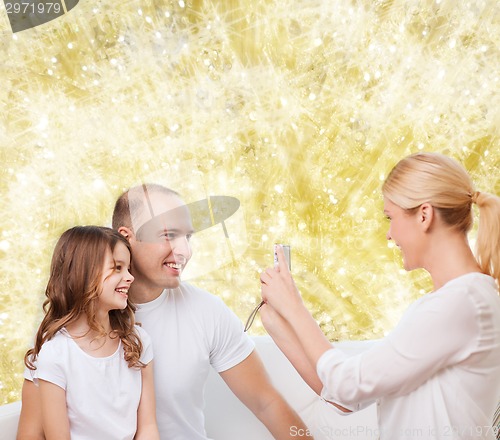 Image of happy family with camera at home