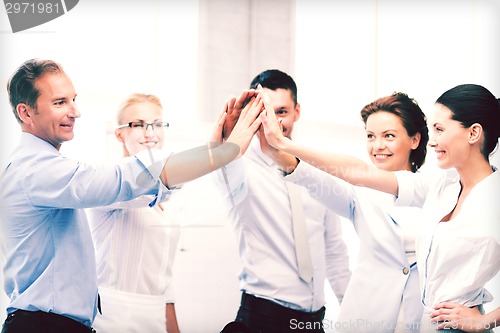 Image of business team celebrating victory in office