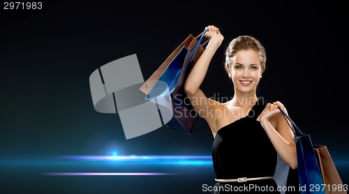 Image of smiling woman in dress with shopping bags
