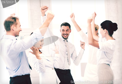 Image of business team celebrating victory in office