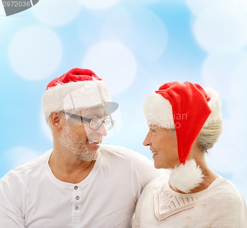 Image of happy senior couple in santa helper hats