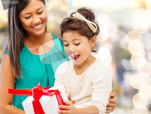 Image of happy mother and little girl with gift box