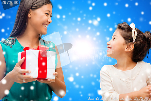 Image of happy mother and little girl with gift box