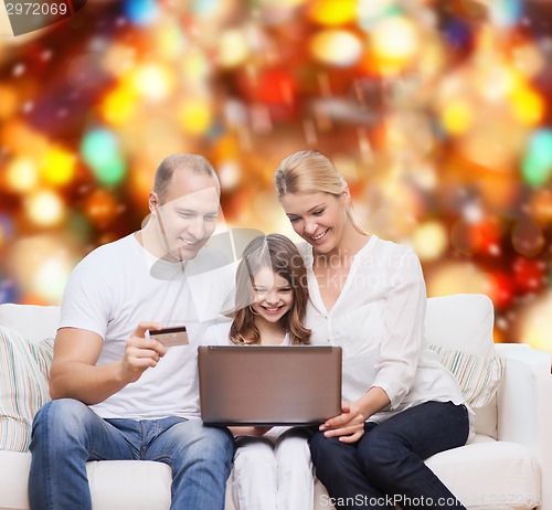 Image of happy family with laptop computer and credit card
