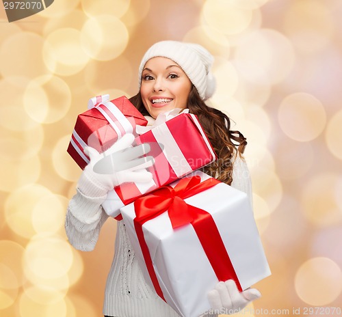 Image of smiling young woman in santa helper hat with gifts