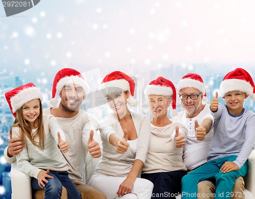 Image of happy family in santa hats showing thumbs up