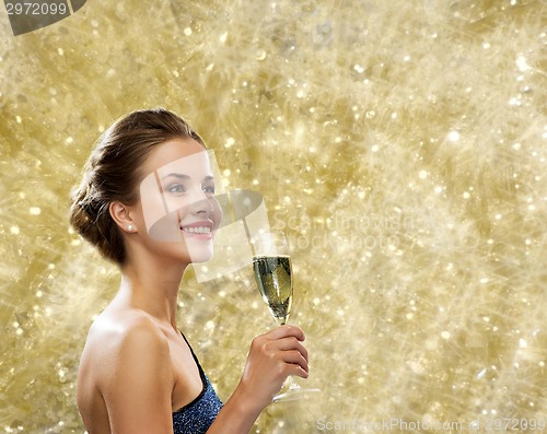 Image of smiling woman holding glass of sparkling wine