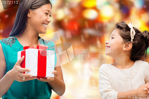 Image of happy mother and little girl with gift box