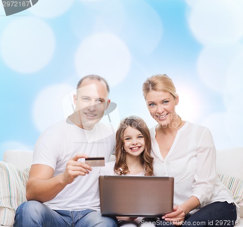 Image of happy family with laptop computer and credit card