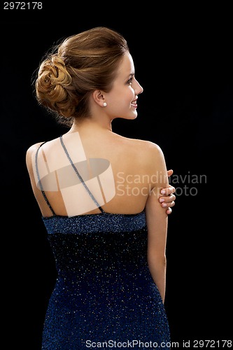 Image of smiling woman in evening dress from the back