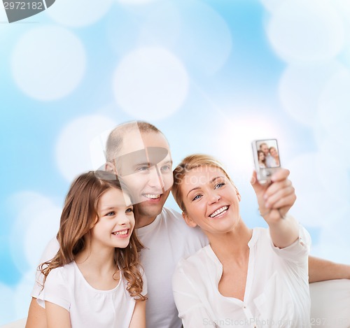 Image of happy family with camera at home