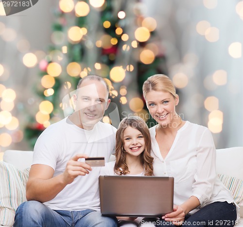Image of happy family with laptop computer and credit card